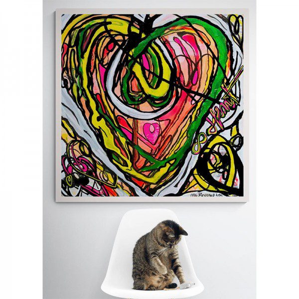 A cat sits on a chair in front of an Infinity Heart Framed Print.