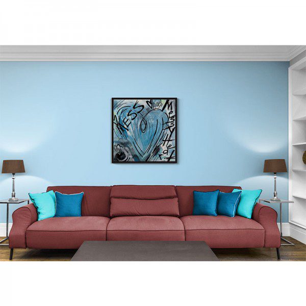 A living room with a Messy Heart Framed Print and blue walls.