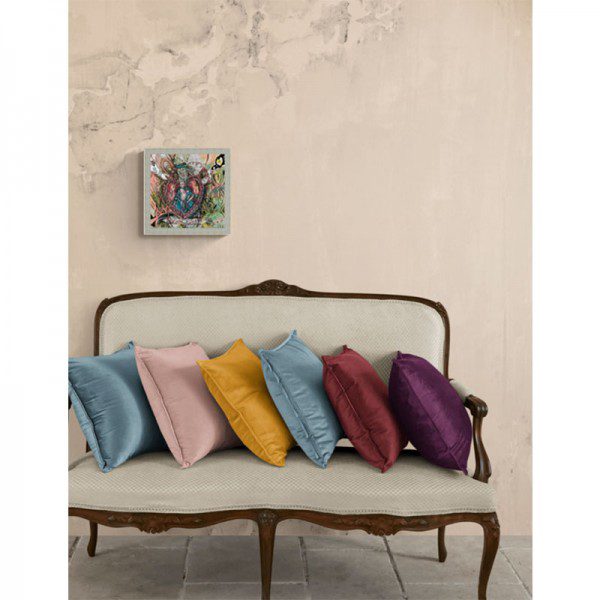Four colorful pillows on a couch in front of a Regal Heart Framed Print.