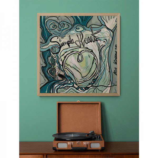A Simple Heart Print with a record on it next to a green wall.