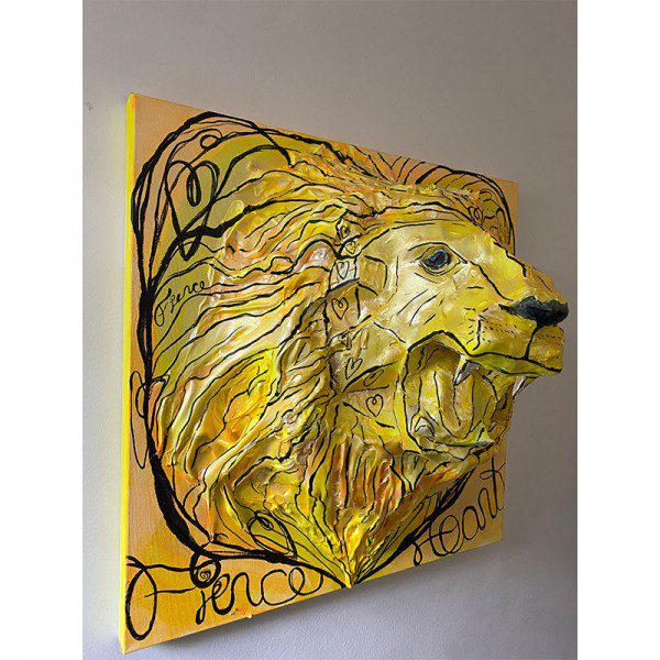 A yellow lion on a wall with writing on it.