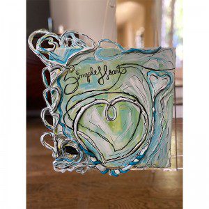 A glass ornament with the words 'Simple Heart' on it.