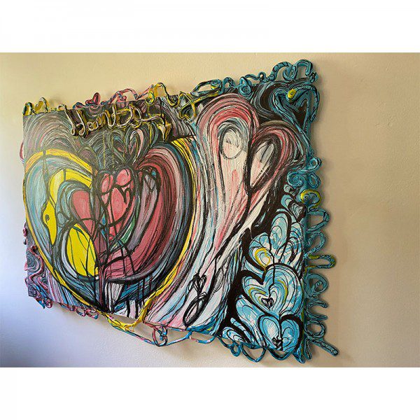 A colorful abstract painting named "Primal Hearts" hanging on a wall.