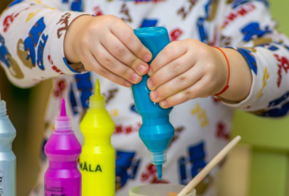 A child is using a squirt gun to paint.