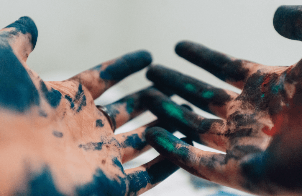An artist's paint-stained hands